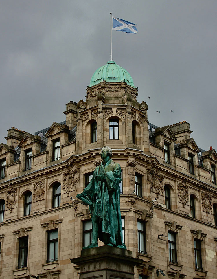building with statue and scottish flag